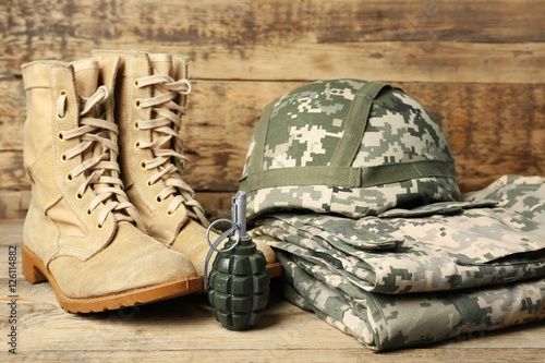 Set of military outfit on wooden background, close up