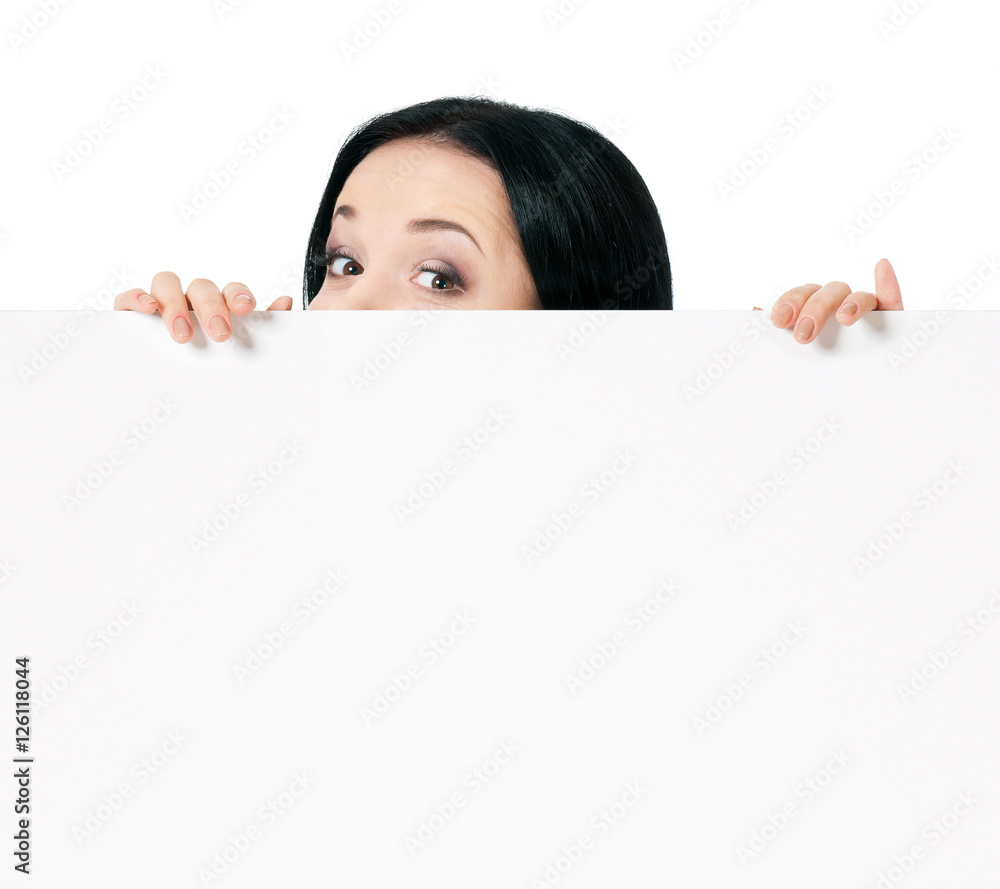 Surprised woman eyes over blank promotional display, isolated on white background. Businesswoman looking over top of white sign. Advertisement business concept - female with white blank board. Surprised woman eyes over blank promotional display, isolated on white background. Businesswoman looking over top of white sign. Advertisement business concept - female with white blank board.