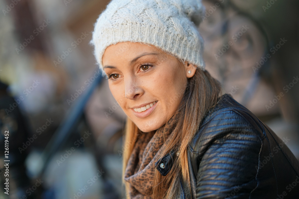 Trendy girl with winter hat sitting on house front porch Trendy girl with winter hat sitting on house front porch