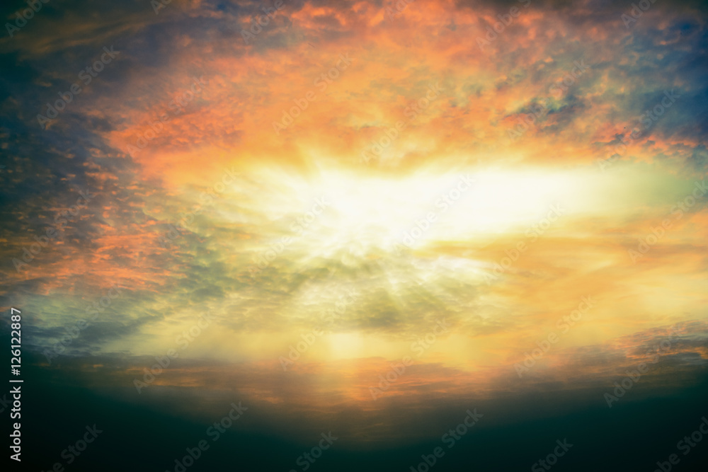 The bright rays of the sun shining from abstract saturated clouds for hope concept