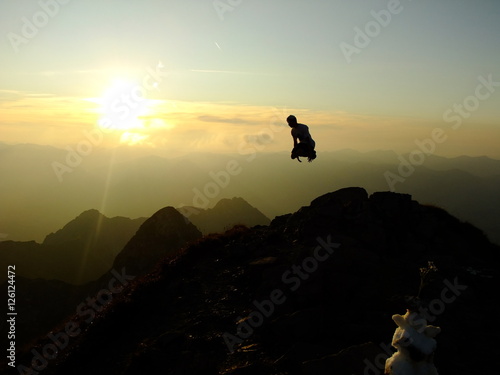 Man jumping up on the Top of the Nebelhorn Mountains in Germany Alps