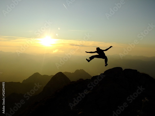 Man jumping high on the Top of the Nebelhorn Mountains in Germany Alps