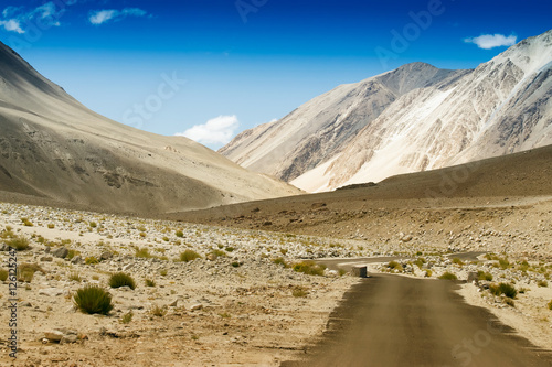 Concrete road towards mountains of Himalaya  Leh  Ladakh