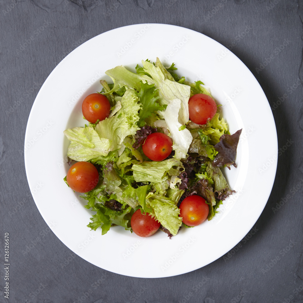 Overhead view of a bowl of fresh garden salad on a rustic slate background