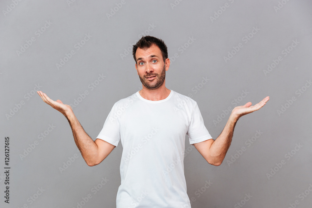 Young casual man standing and holding copyspace on both palms Young casual man standing and holding copyspace on both palms
