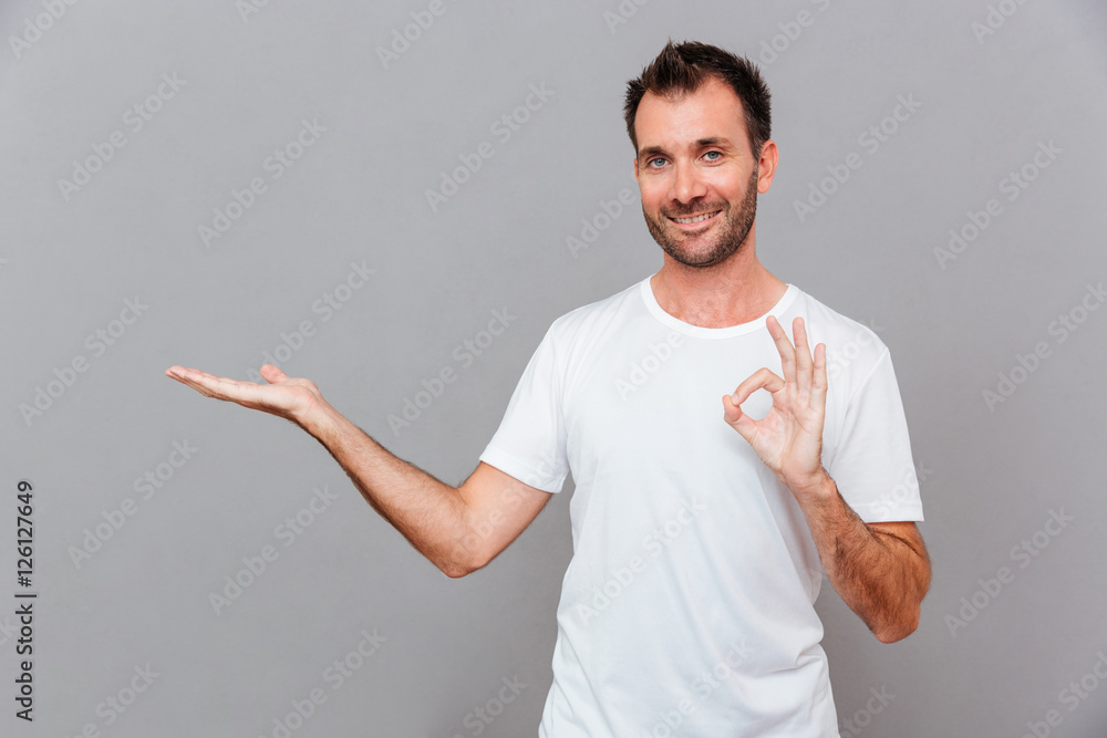 Man in shirt and gray pants holding copyspace on palm Man in shirt and gray pants holding copyspace on palm