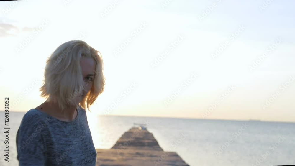 Beautiful girl walks smiling and happy near the beach at sunrise Beautiful girl walks smiling and happy near the beach at sunrise
