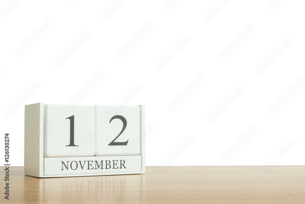 Closeup surface white wooden calendar with black 12 november word on blurred brown wood desk isolated on white background with copy space , selective focus at the calendar