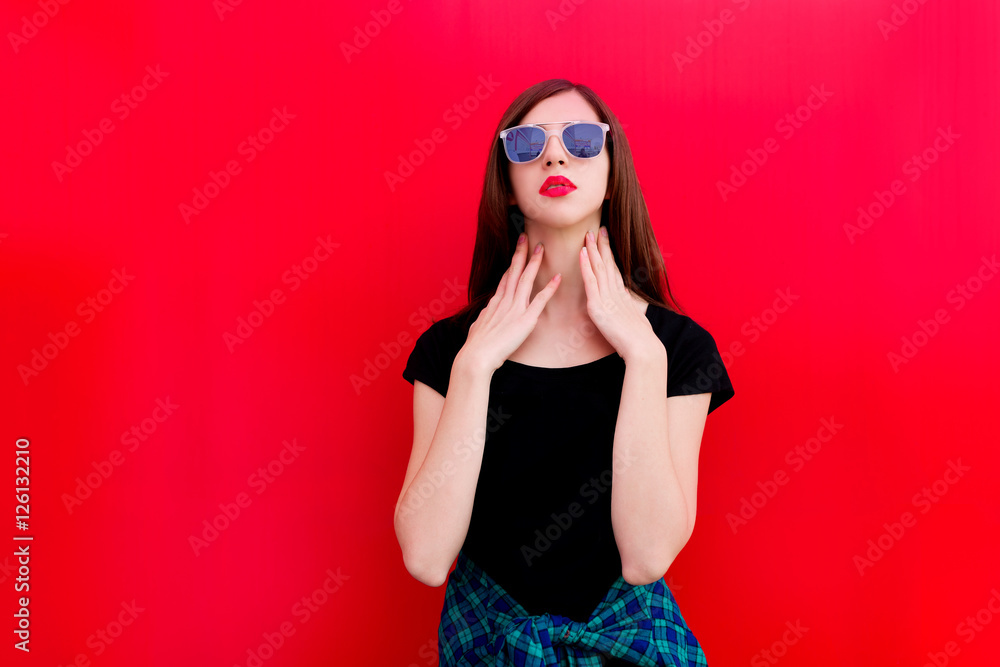 Portrait of girl in rock black style, standing outdoors in the city against the red urban wall Portrait of girl in rock black style, standing outdoors in the city against the red urban wall