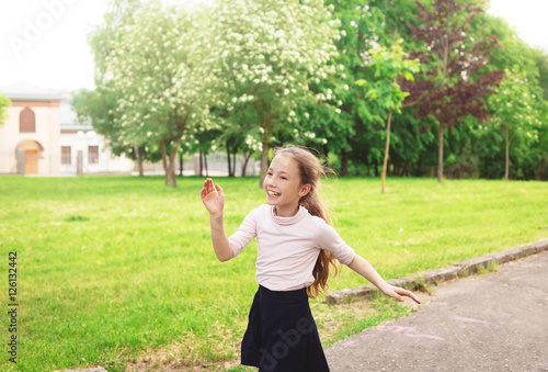 Happy child girl running on meadow in summer day