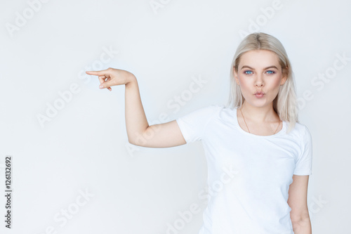 Beauty young woman pointing away over white background photo