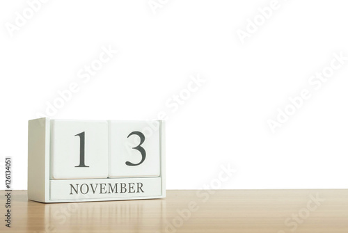 Closeup surface white wooden calendar with black 13 november word on blurred brown wood desk isolated on white background with copy space , selective focus at the calendar