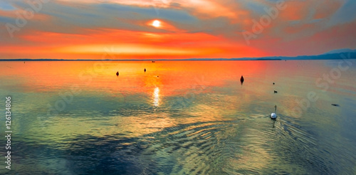 Cielo rosso al calar del sole sul lago di Garda con cigno © Franco Visintainer
