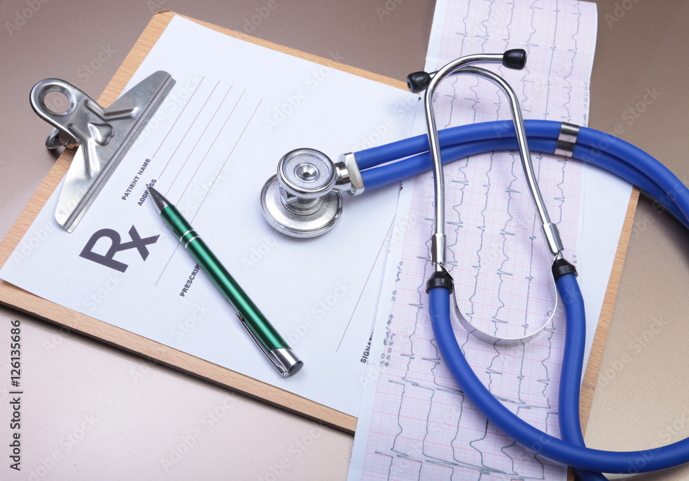 Stethoscope head and silver pen lying on cardiogram clipboard pad. Cardio therapeutist assistance, physician make cardiac physical, pulse beat measure document, arrhythmia idea, pacemaker concept Stethoscope head and silver pen lying on cardiogram clipboard pad. Cardio therapeutist assistance, physician make cardiac physical, pulse beat measure document, arrhythmia idea, pacemaker concept