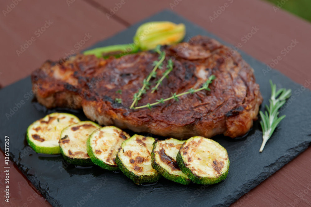 Rib eye steak with vegetables on a slate plate