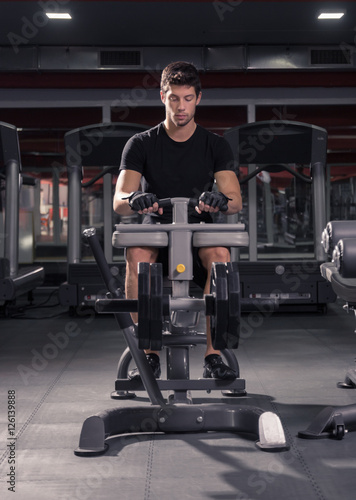 man seated calf raise machine, gym.