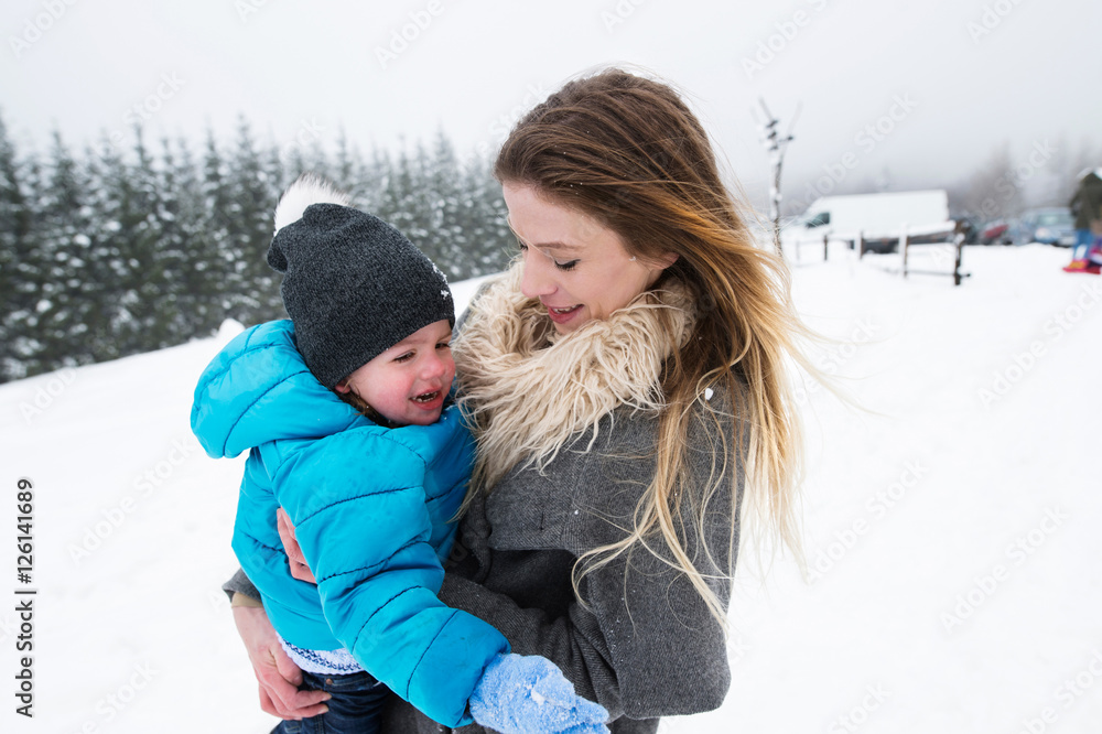 Obraz premium Mother having fun with her son. Winter nature.