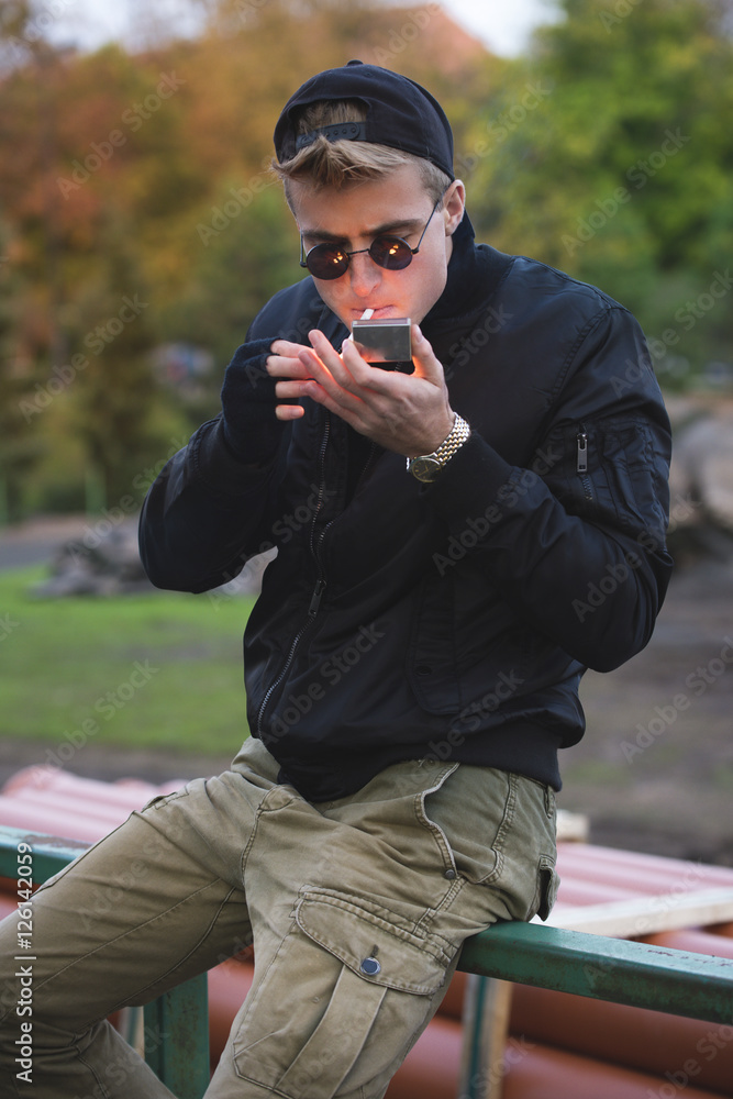 Young handsome blond haired hooligan with cigaretes Young handsome blond haired hooligan with cigaretes