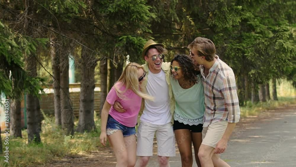 Two happy multiethnic couples enjoying life, laughing in park, summer holidays Two happy multiethnic couples enjoying life, laughing in park, summer holidays