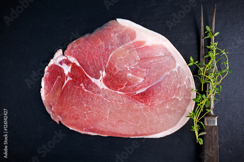 Fotografija Raw gammon steak on black stone background