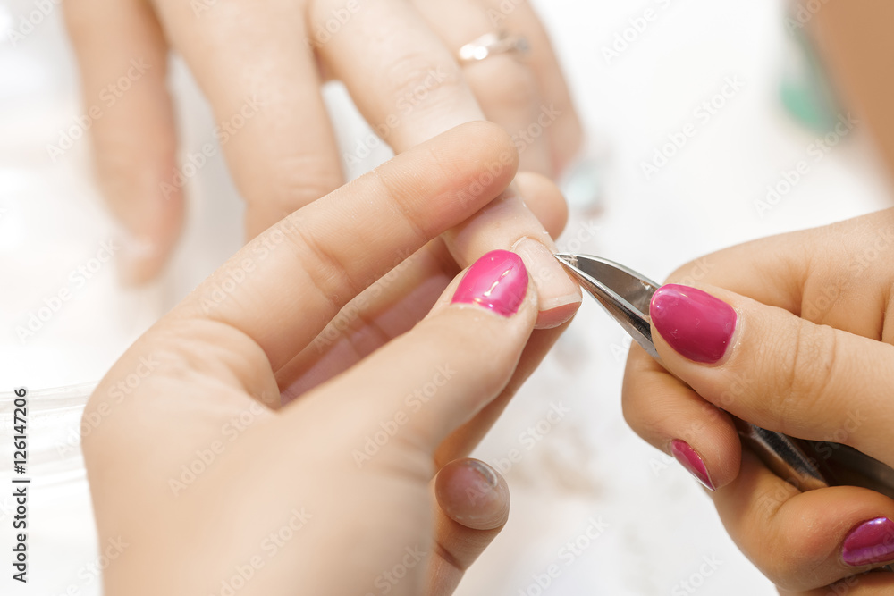 Manicurist uses professional manicure tool. Manicurist uses professional manicure tool.