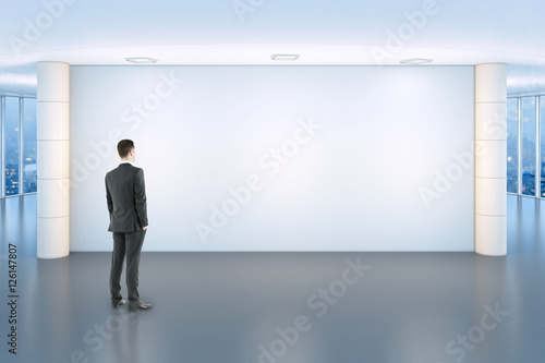 Businessman looking at blank wall