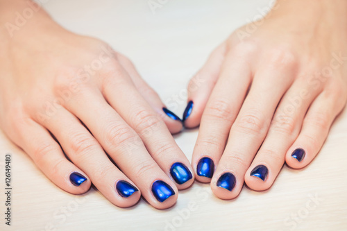 female hands with  blue nail Polish, close-up