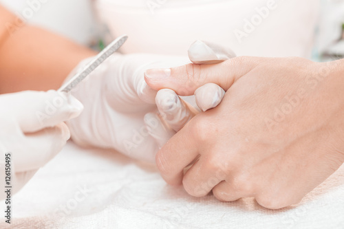 woman in a beauty salon receiving manicure