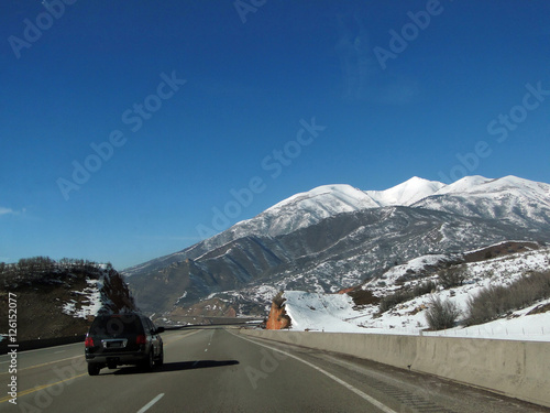 Driving through canyon under Book Cliffs sedimentary formations, along I-70 highway near Grand Junction, Colorado