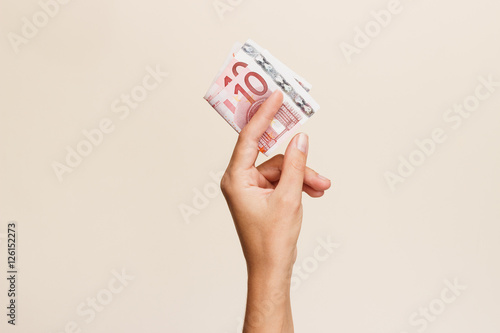 Woman's hand with money on a light background