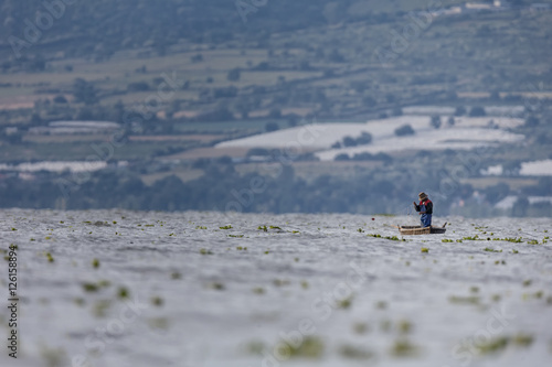 Traditional Mexican fishermen throwing fishing net at lake chapa