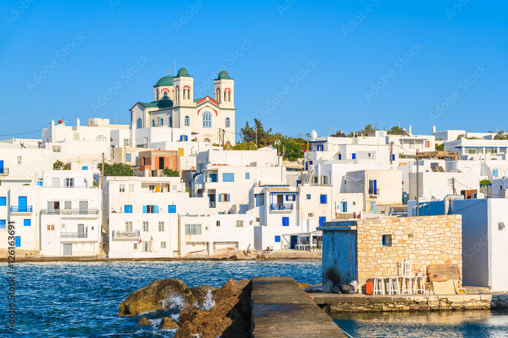 Traditional white houses and church in Naoussa port at sunset time, Paros island, Greece