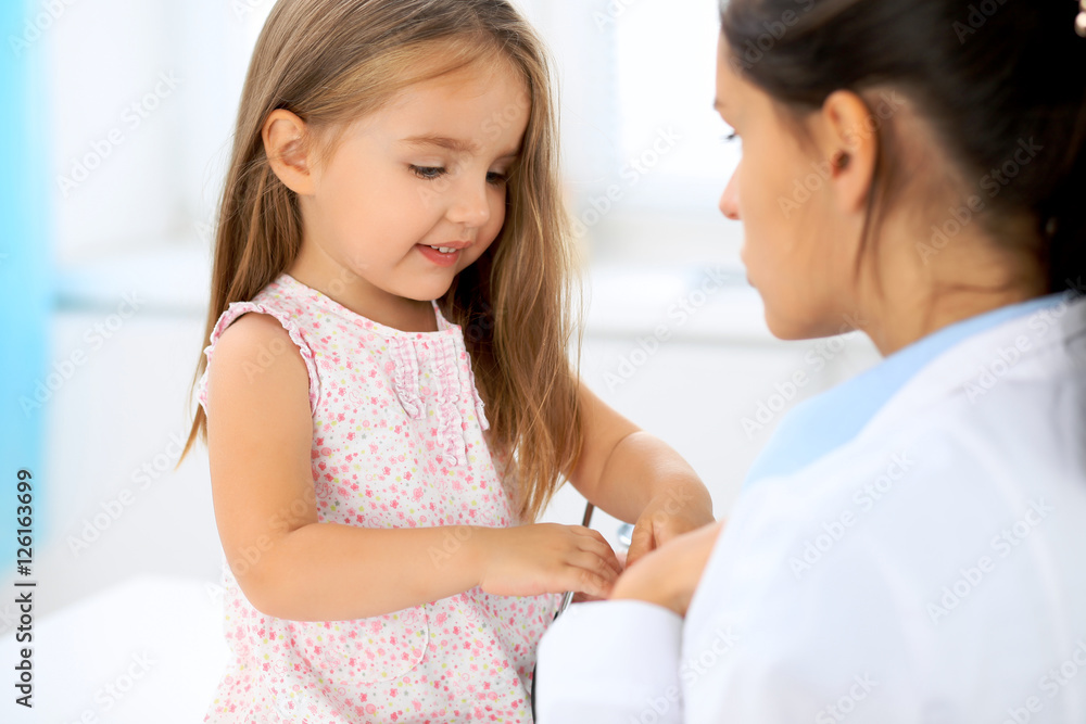 Happy little girl at health exam at doctor's office Happy little girl at health exam at doctor's office