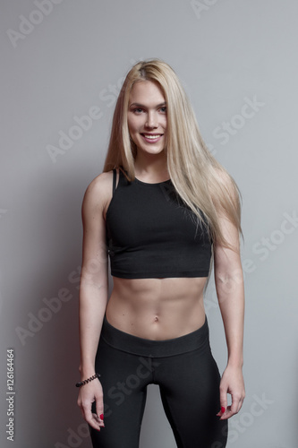 Portrait of a blonde woman wearing sports clothing in gym © Artem Varnitsin