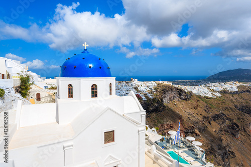 Blue dome of church in Imerovigli village and view of blue sea with caldera on Santorini island, Greece