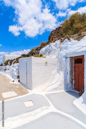 Narrow street in Oia village with typical white Greek architecture, Santorini island, Greece