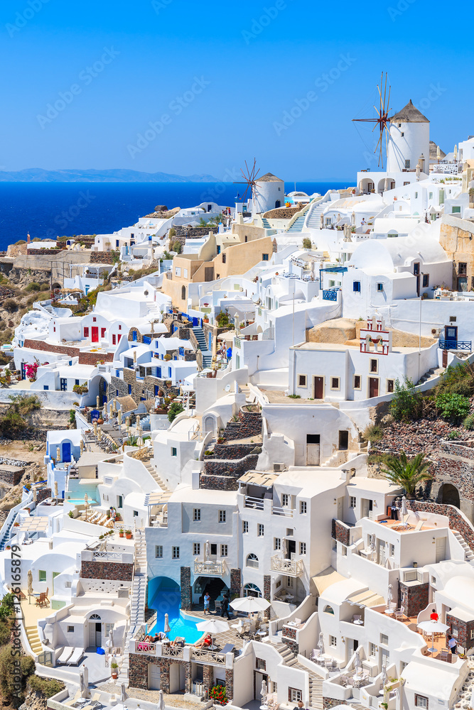 White houses and traditional windmill in Oia village on Santorini island, Greece
