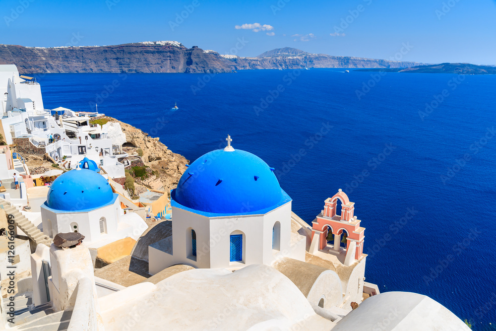 Famous blue domes of white churches in Oia village on Santorini island, Greece