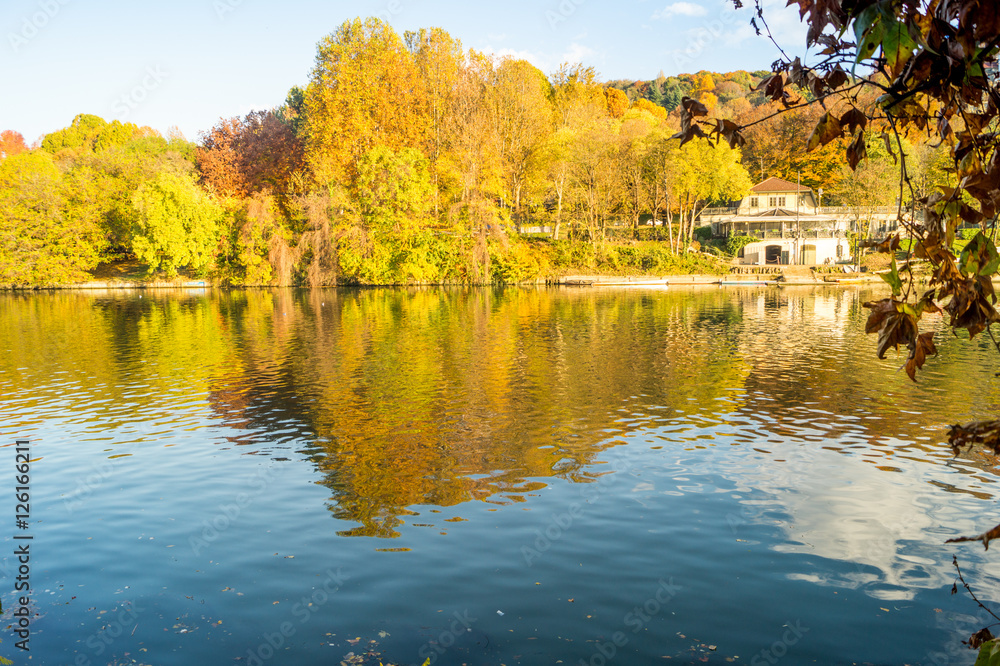 Fototapeta premium Colorfull italian park with trees and autumn colors and water