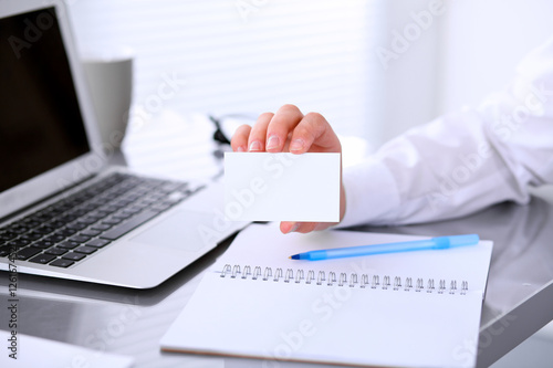 Close-up of business woman giving a visit card