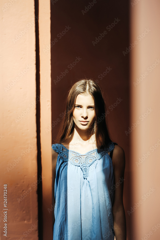 Fototapeta premium Young woman near brown building