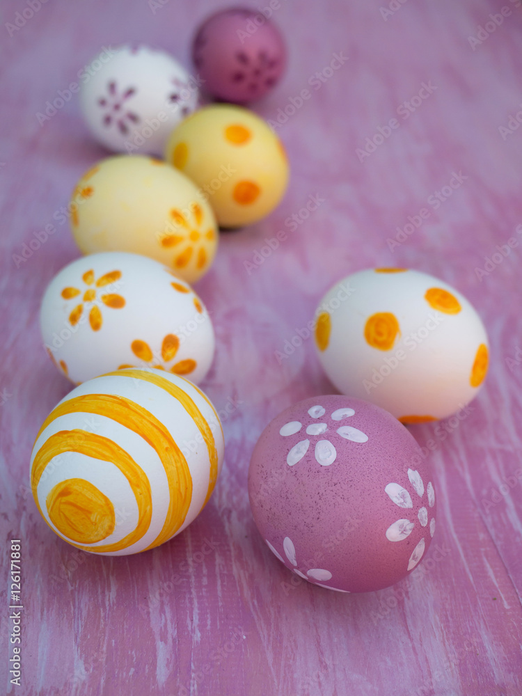 Colorful Easter eggs composition on the violet wooden board