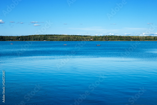 Landscape with the river in the sunny day. Water of deep blue color.