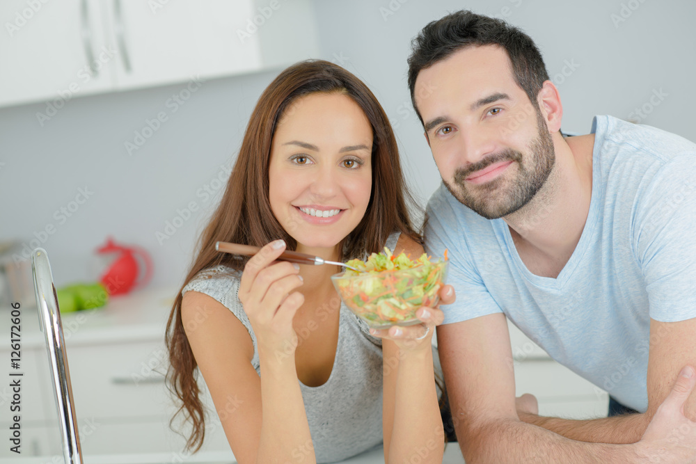 Fotografie Couple sharing a salad in the kitchen