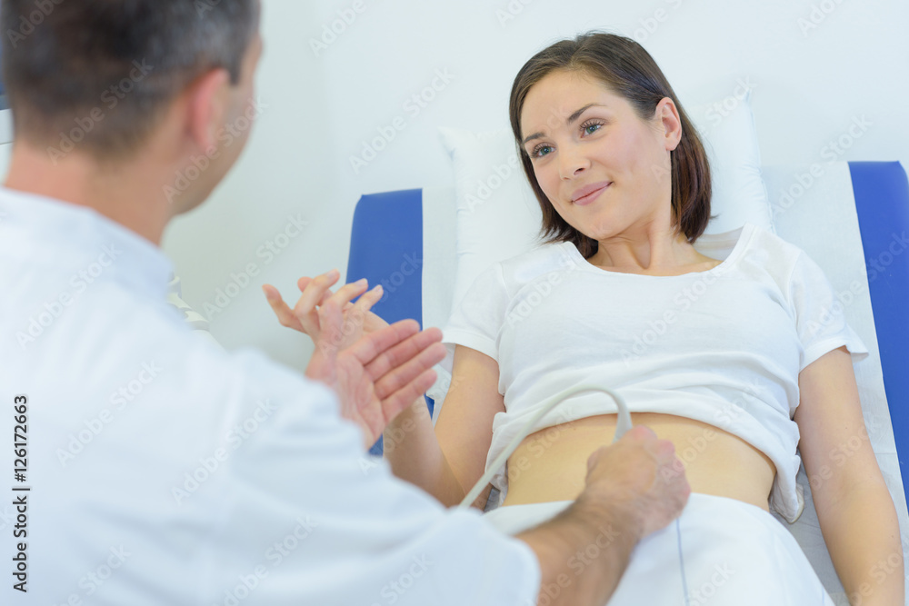 Lady having abdomen scan, hand raised Lady having abdomen scan, hand raised