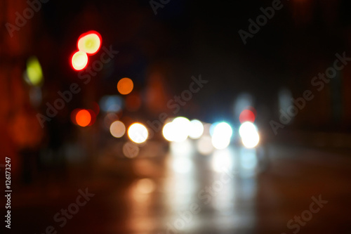 NIht in the city blurred shot. Cars in the street with reflections of carlights in asphalt road surface shot with space for text