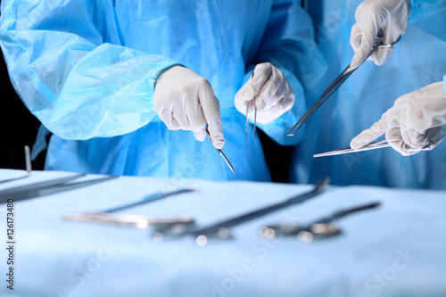 Medical team performing operation. Group of surgeon is working in operating theatre toned in blue