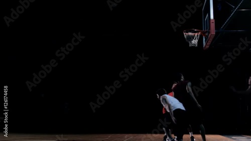 Basketball player passing the defensive players to make a layup shot. photo