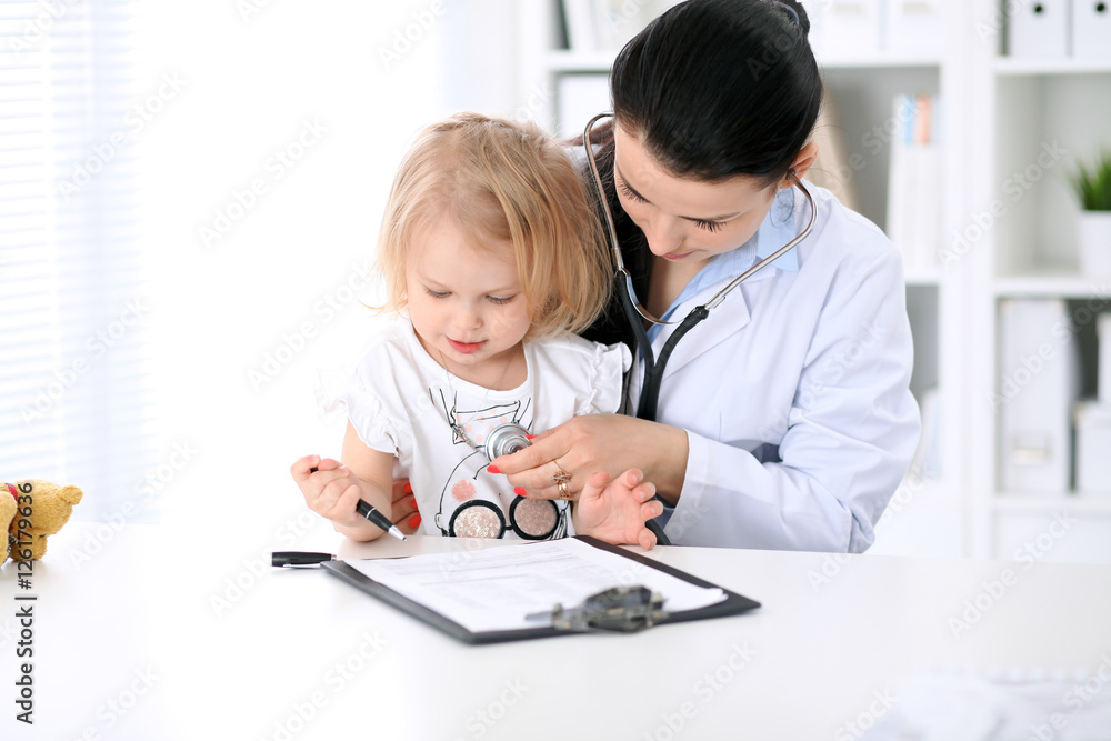 Pediatrician is taking care of baby in hospital. Little girl is being examine by doctor with stethoscope. Health care, insurance and help concept. Pediatrician is taking care of baby in hospital. Little girl is being examine by doctor with stethoscope. Health care, insurance and help concept.