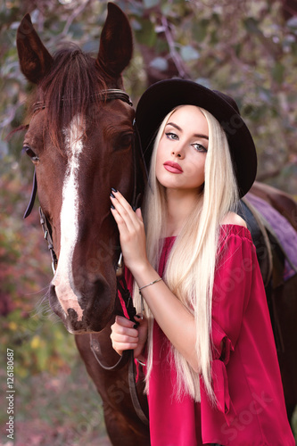 Close-up portrait of a beautiful caucasian girl holding a horse